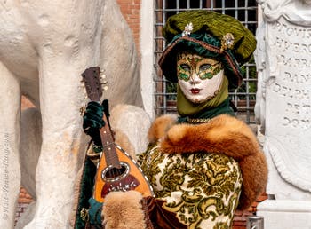 People in costume at the Venice Carnival in front of the Venetian Arsenal.