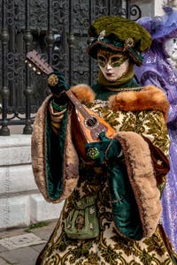 People in costume at the Venice Carnival in front of the Venetian Arsenal.