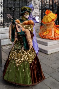 People in costume at the Venice Carnival in front of the Venetian Arsenal.