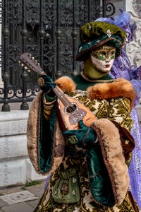 People in costume at the Venice Carnival in front of the Venetian Arsenal.