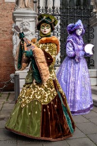 People in costume at the Venice Carnival in front of the Venetian Arsenal.