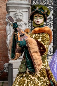 People in costume at the Venice Carnival in front of the Venetian Arsenal.