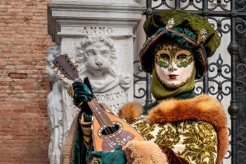 People in costume at the Venice Carnival in front of the Venetian Arsenal.