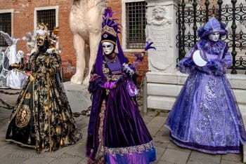 People in costume at the Venice Carnival in front of the Venetian Arsenal.