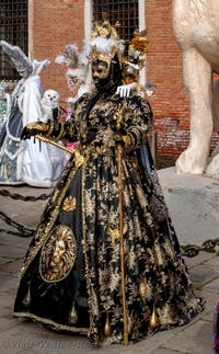 People in costume at the Venice Carnival in front of the Venetian Arsenal.