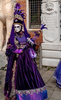 People in costume at the Venice Carnival in front of the Venetian Arsenal.