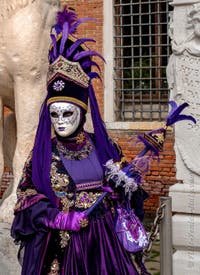 People in costume at the Venice Carnival in front of the Venetian Arsenal.