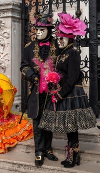 People in costume at the Venice Carnival in front of the Venetian Arsenal.