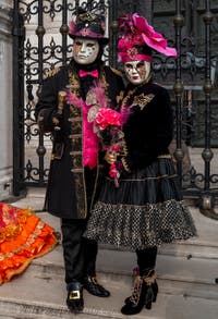 People in costume at the Venice Carnival in front of the Venetian Arsenal.