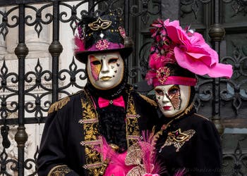 People in costume at the Venice Carnival in front of the Venetian Arsenal.