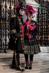 People in costume at the Venice Carnival in front of the Venetian Arsenal.