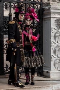 People in costume at the Venice Carnival in front of the Venetian Arsenal.