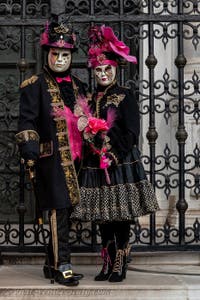 People in costume at the Venice Carnival in front of the Venetian Arsenal.