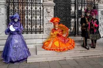 People in costume at the Venice Carnival in front of the Venetian Arsenal.