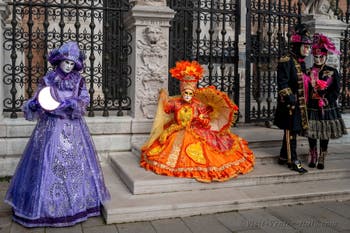 People in costume at the Venice Carnival in front of the Venetian Arsenal.