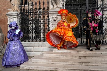 People in costume at the Venice Carnival in front of the Venetian Arsenal.