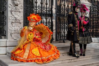 People in costume at the Venice Carnival in front of the Venetian Arsenal.