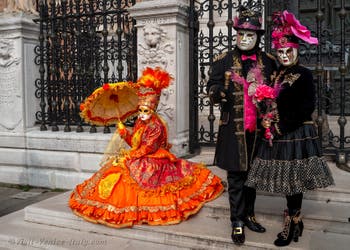 People in costume at the Venice Carnival in front of the Venetian Arsenal.