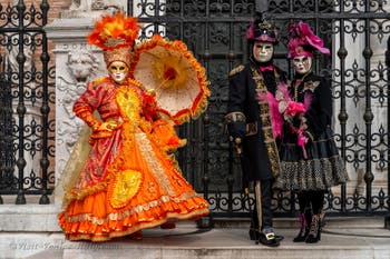 People in costume at the Venice Carnival in front of the Venetian Arsenal.