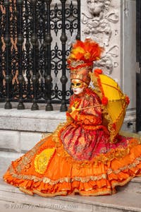 People in costume at the Venice Carnival in front of the Venetian Arsenal.