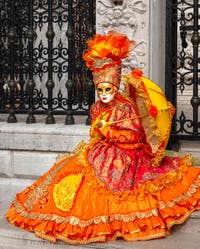 People in costume at the Venice Carnival in front of the Venetian Arsenal.