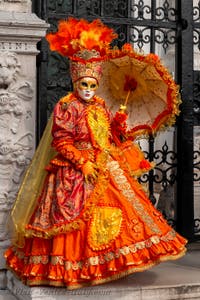 People in costume at the Venice Carnival in front of the Venetian Arsenal.