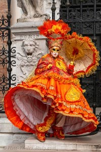 People in costume at the Venice Carnival in front of the Venetian Arsenal.