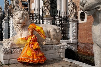 People in costume at the Venice Carnival in front of the Venetian Arsenal.