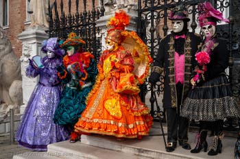 People in costume at the Venice Carnival in front of the Venetian Arsenal.