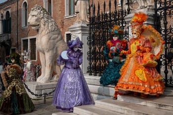 People in costume at the Venice Carnival in front of the Venetian Arsenal.