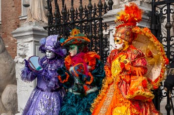 People in costume at the Venice Carnival in front of the Venetian Arsenal.