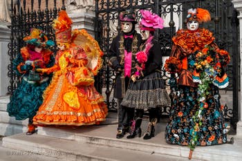 People in costume at the Venice Carnival in front of the Venetian Arsenal.