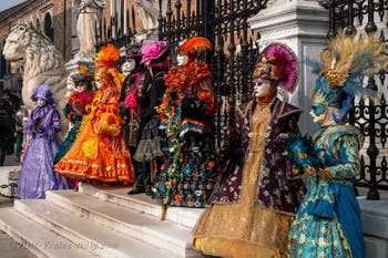 People in costume at the Venice Carnival in front of the Venetian Arsenal.