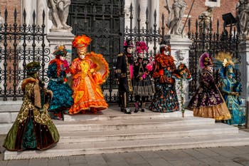 People in costume at the Venice Carnival in front of the Venetian Arsenal.