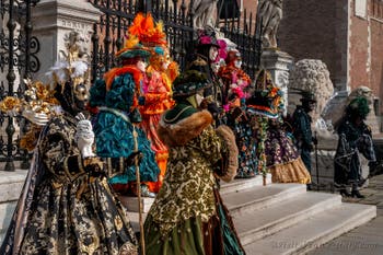 People in costume at the Venice Carnival in front of the Venetian Arsenal.