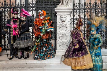 People in costume at the Venice Carnival in front of the Venetian Arsenal.