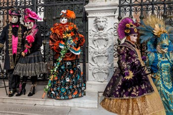 People in costume at the Venice Carnival in front of the Venetian Arsenal.