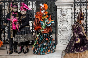 People in costume at the Venice Carnival in front of the Venetian Arsenal.