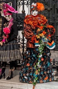 People in costume at the Venice Carnival in front of the Venetian Arsenal.