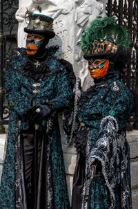 People in costume at the Venice Carnival in front of the Venetian Arsenal.