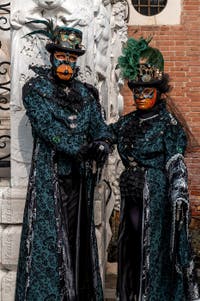 People in costume at the Venice Carnival in front of the Venetian Arsenal.