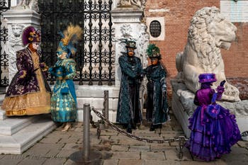 People in costume at the Venice Carnival in front of the Venetian Arsenal.