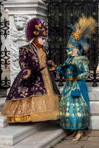 People in costume at the Venice Carnival in front of the Venetian Arsenal.