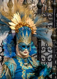 People in costume at the Venice Carnival in front of the Venetian Arsenal.