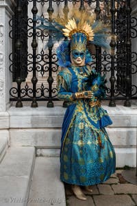 People in costume at the Venice Carnival in front of the Venetian Arsenal.