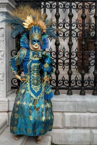 People in costume at the Venice Carnival in front of the Venetian Arsenal.