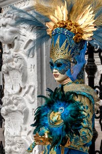 People in costume at the Venice Carnival in front of the Venetian Arsenal.