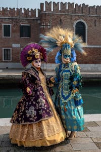 People in costume at the Venice Carnival in front of the Venetian Arsenal.