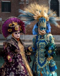 People in costume at the Venice Carnival in front of the Venetian Arsenal.