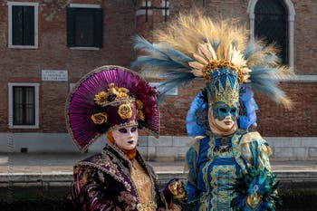 People in costume at the Venice Carnival in front of the Venetian Arsenal.